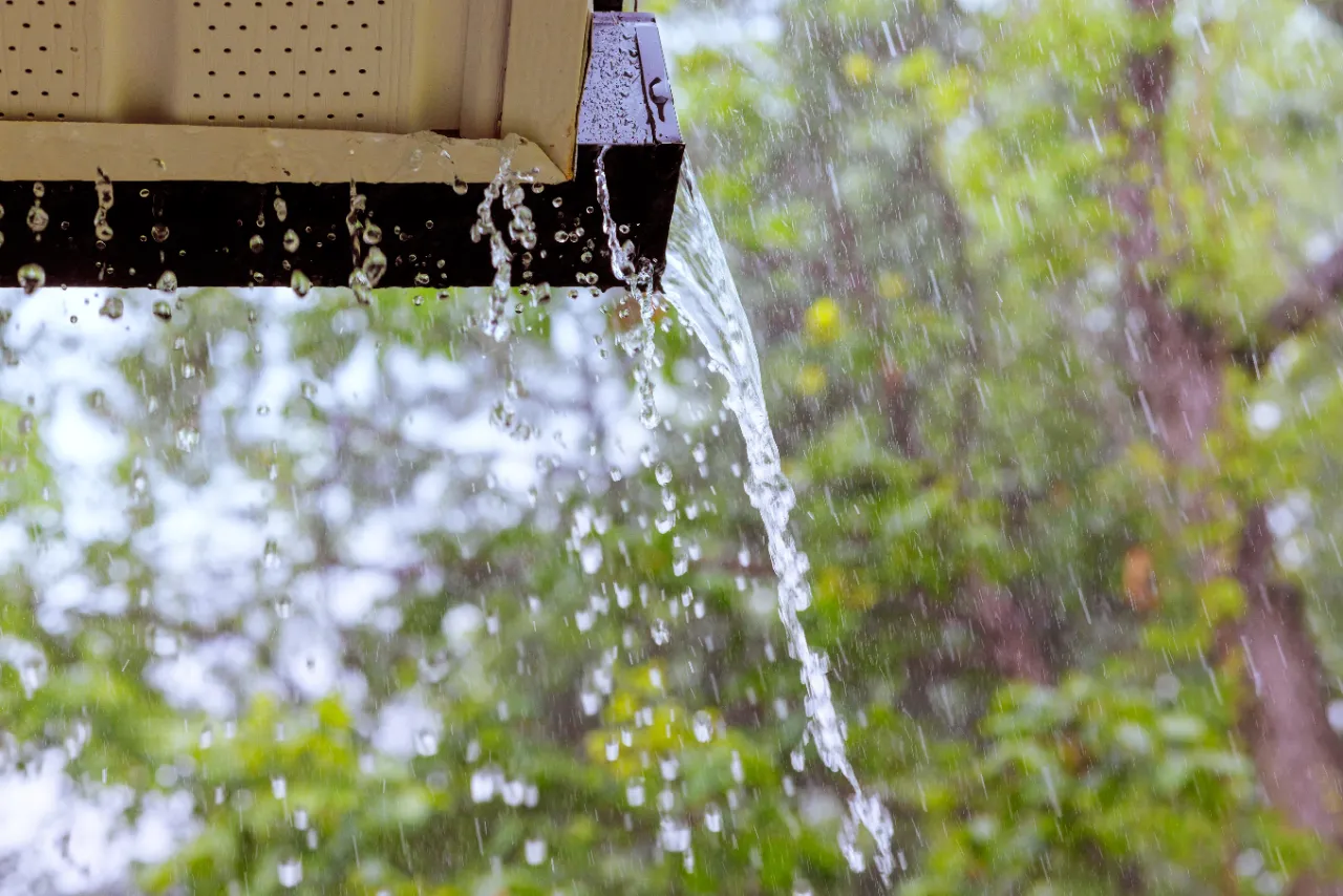 Rainwater streaming from an eaves trough during a storm